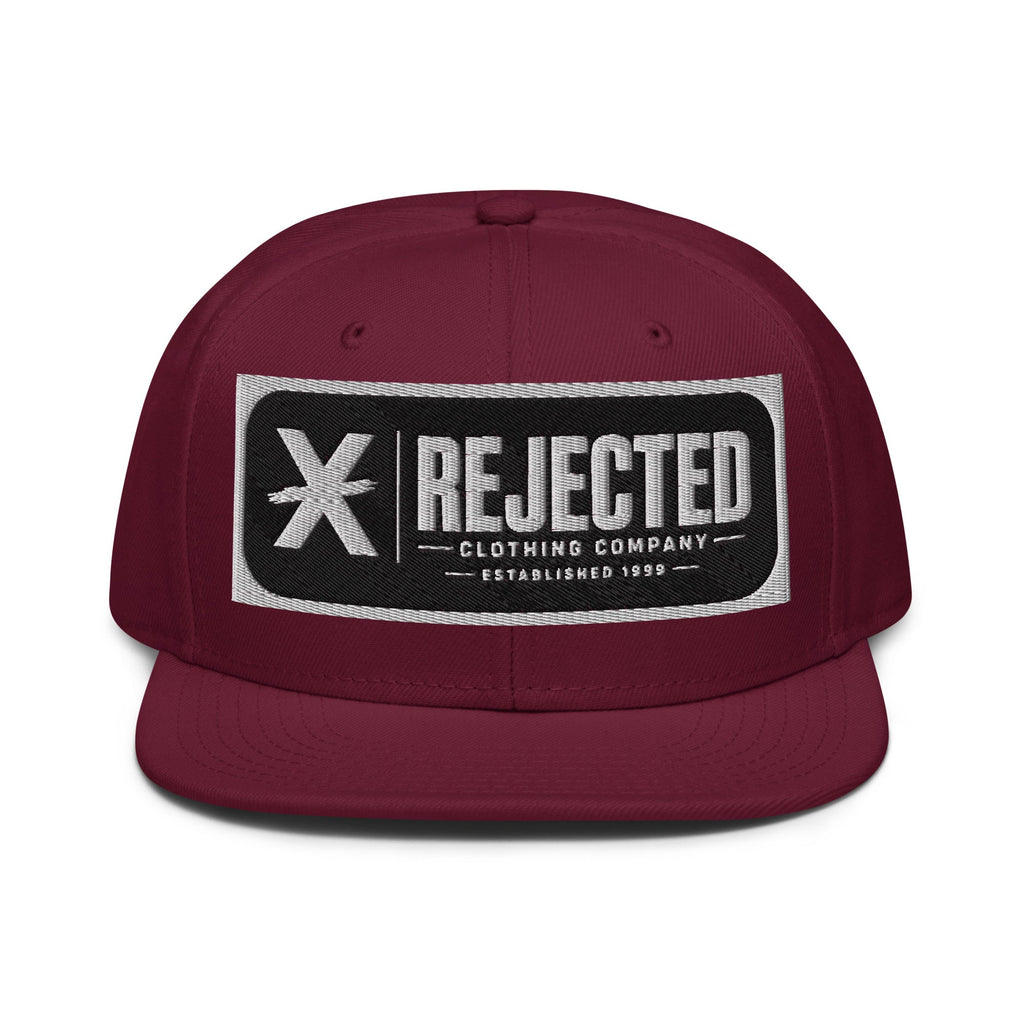 Black snapback with a teal brim and an embroidered Rejected Clothing Company Established 1999 patch
