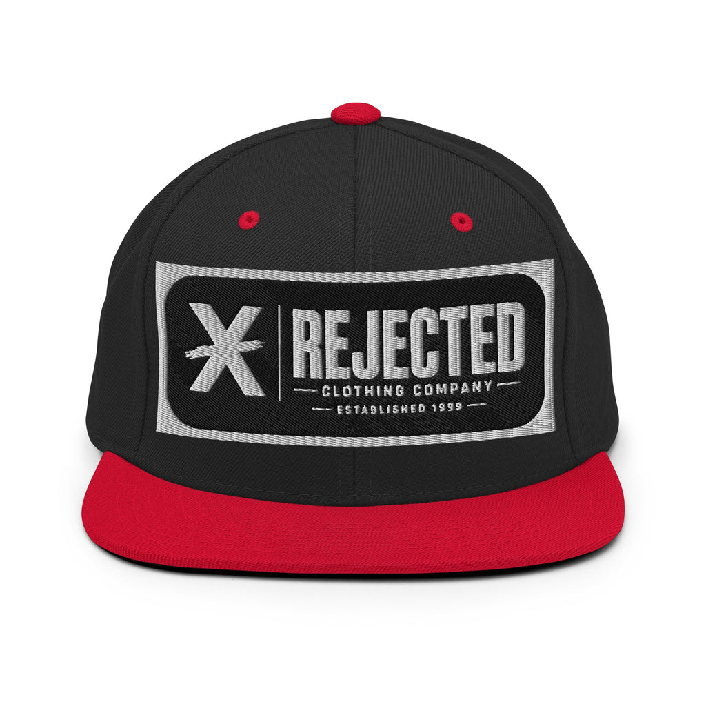 All-black snapback with an embroidered Rejected Clothing Company Established 1999 patch and a green undervisor