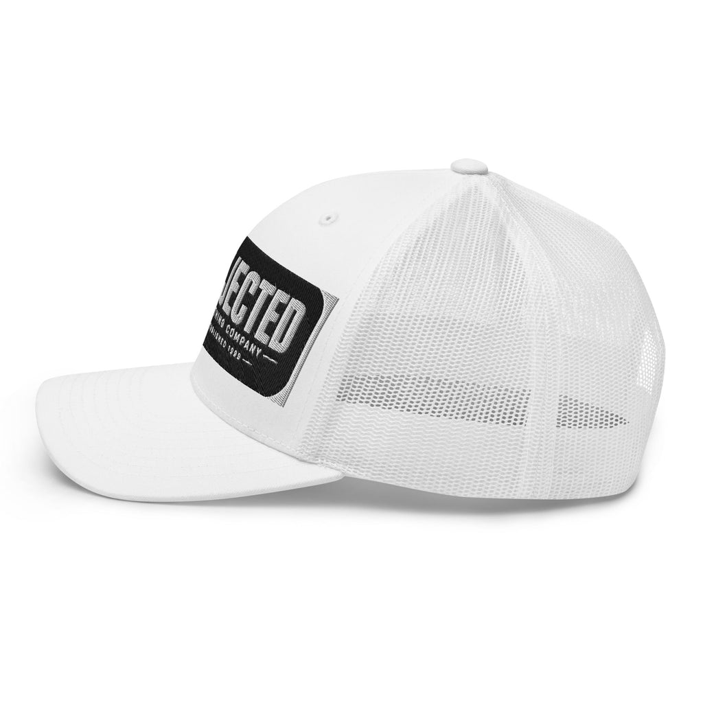 White trucker cap with an embroidered Rejected Clothing Company Established 1999 patch and X mark