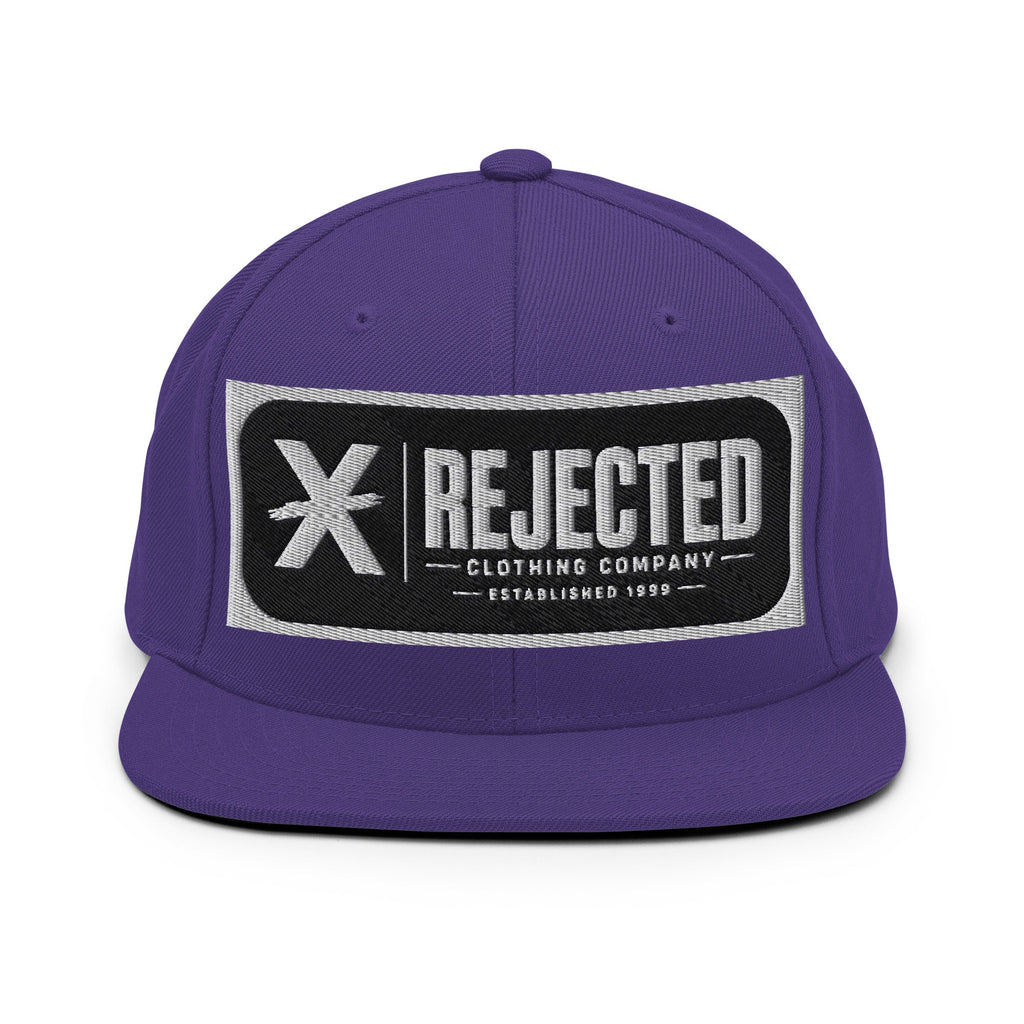 All-black snapback with an embroidered Rejected Clothing Company Established 1999 patch and a green undervisor