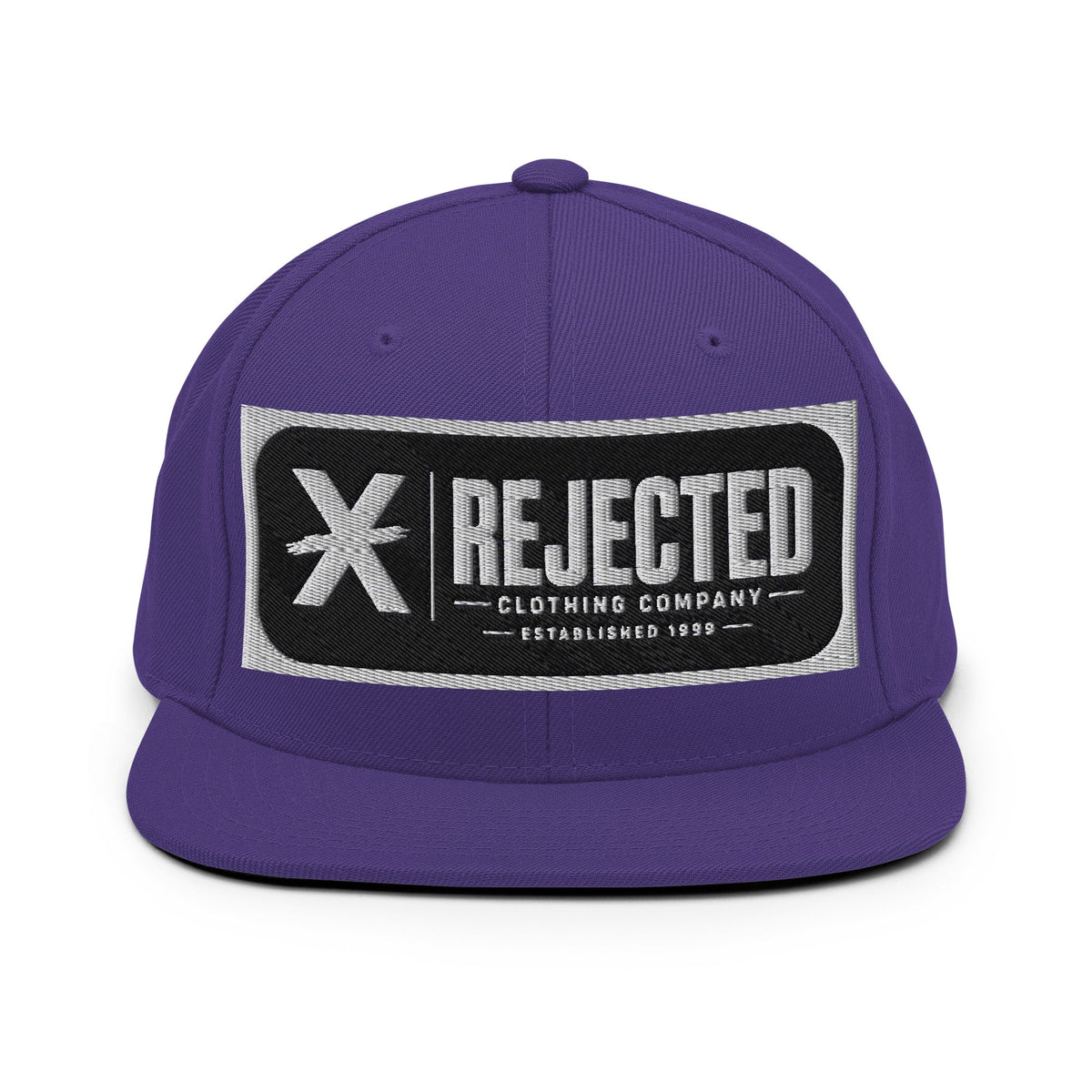 All-black snapback with an embroidered Rejected Clothing Company Established 1999 patch and a green undervisor