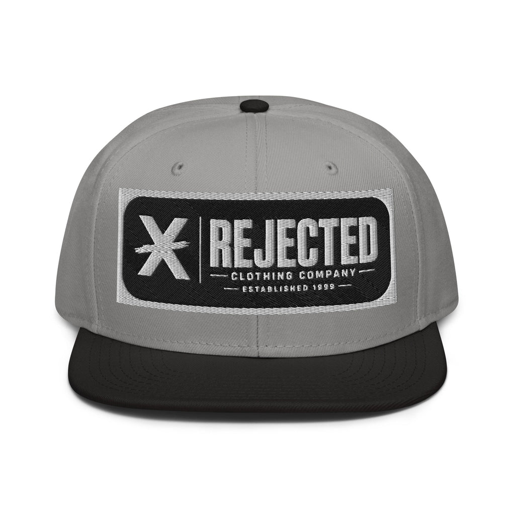 Black snapback with a teal brim and an embroidered Rejected Clothing Company Established 1999 patch