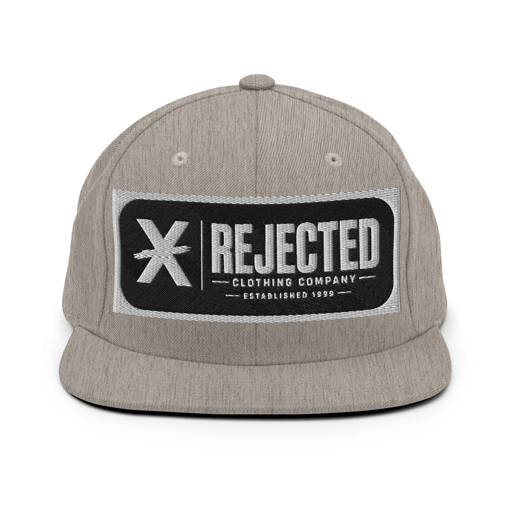 All-black snapback with an embroidered Rejected Clothing Company Established 1999 patch and a green undervisor