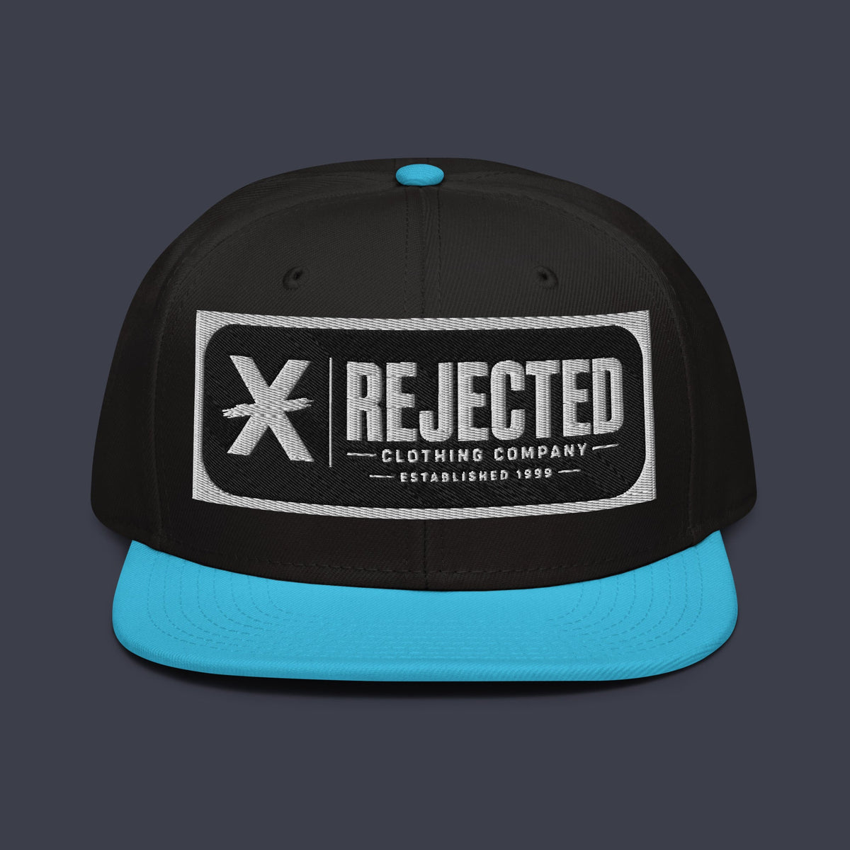 Black snapback with a teal brim and an embroidered Rejected Clothing Company Established 1999 patch