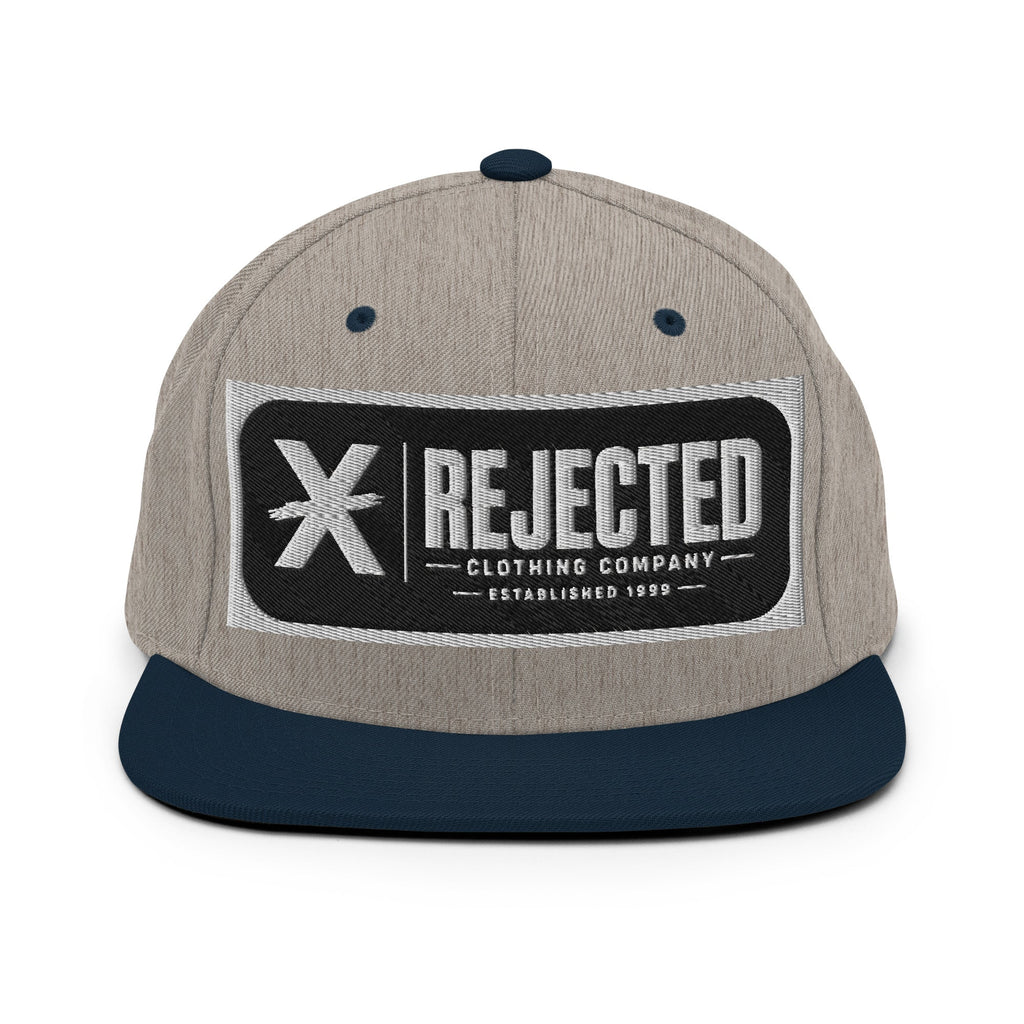 All-black snapback with an embroidered Rejected Clothing Company Established 1999 patch and a green undervisor